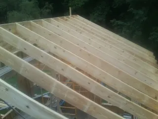 New roof rafters set over an addition before sheathing in Freeman